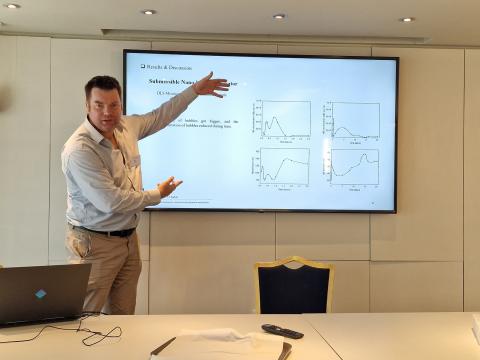 Prof. Niall English presenting in front of a screen